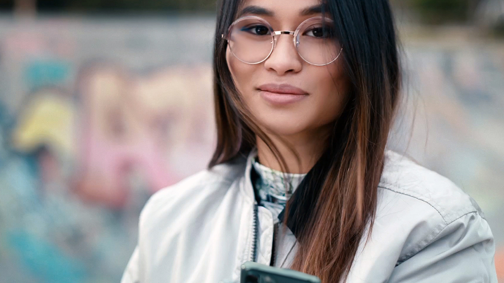 Gördeszkaparkban tartózkodó fiatal nő, aki ZEISS Monofocal SmartLife szemüveglencsét visel.