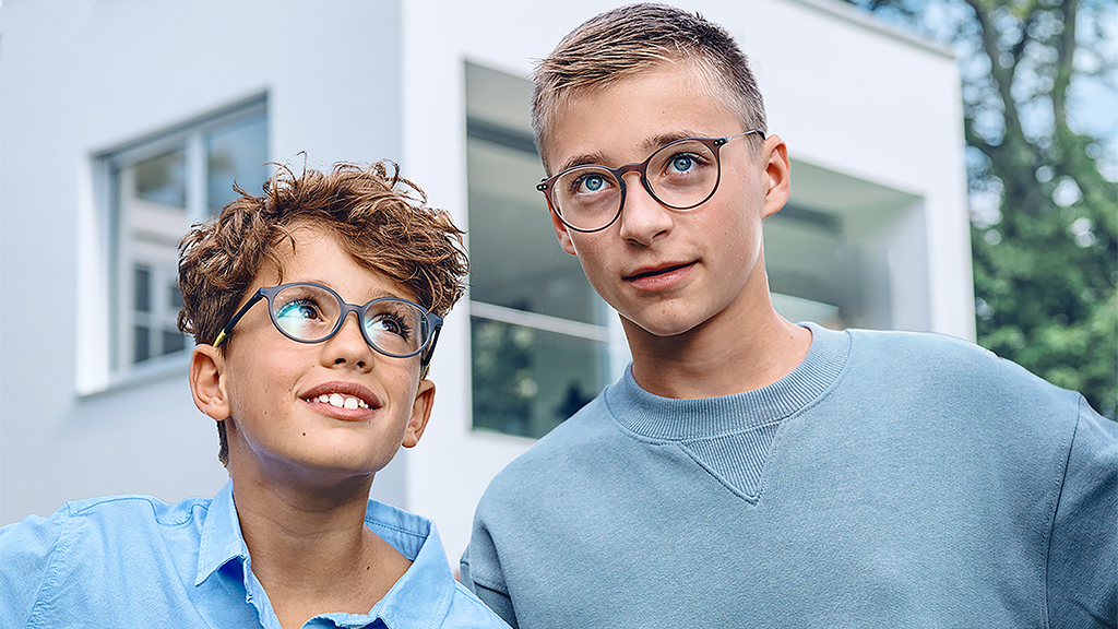 Egy tinédzserre felnéző fiatal fiú, mindketten ZEISS Monofocal SmartLife Young szemüveget viselnek